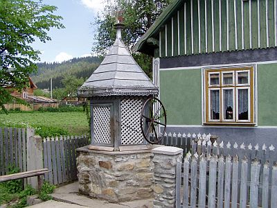 Typical well and traditional farmhouse in the Bukovina